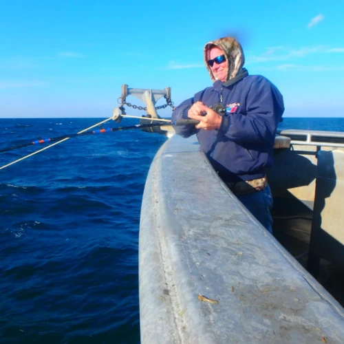 An angler fishing off the side of a large boat