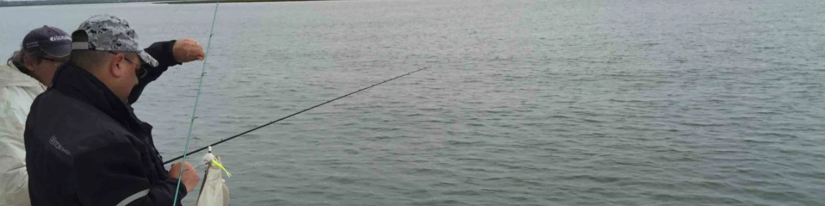 An angler fishing in the rocks of the surf