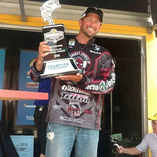 Dave Mullins standing on a stage holding a trophy