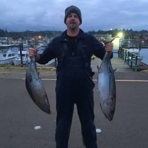 An angler holding two tuna
