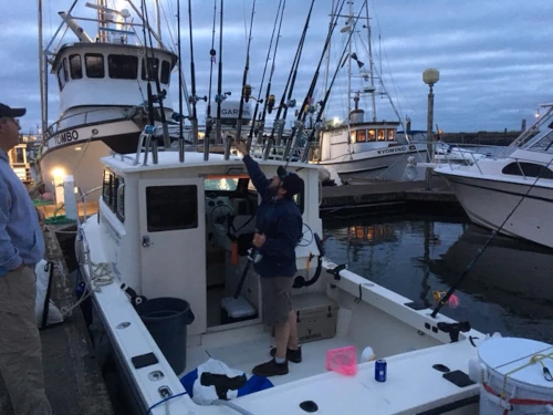 An angler getting fishing rods ready on a charter boat
