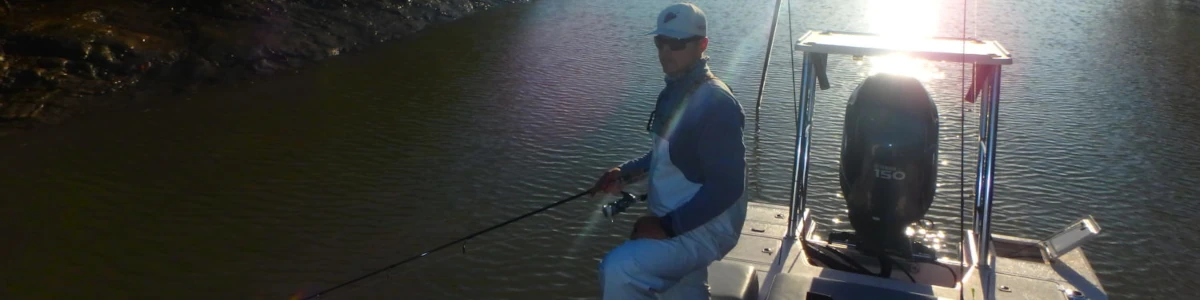 Close-up of Captain Mike Venezia standing on a boat fishing in the canal water