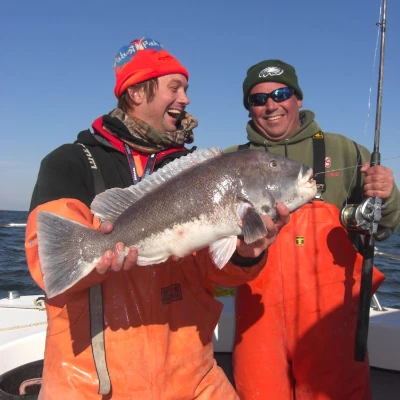 Nick Honachefsky and another angler holding a fish and fishing rod