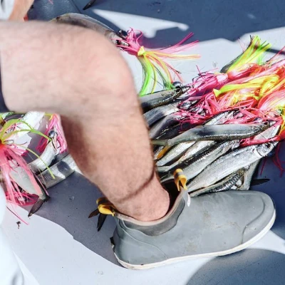 An angler's leg who is wearing Xtratuf fishing deck boots
