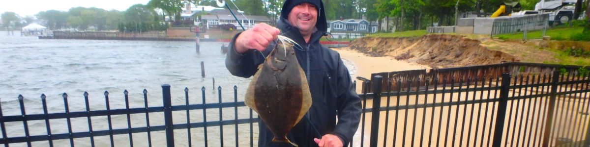Close-up of an angler on the pier holding a fluke