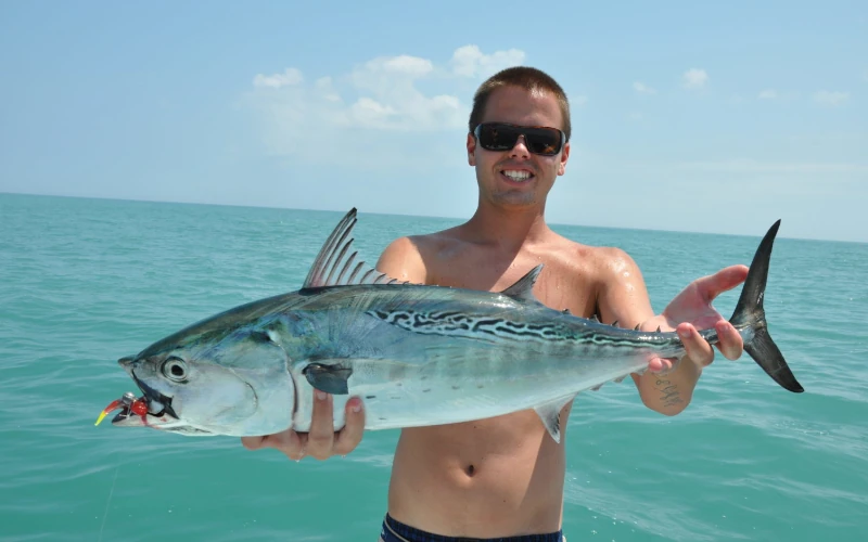 An angler holding a false albacore (bonito) fish