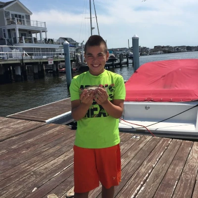 A boy angler holing a small bluefish