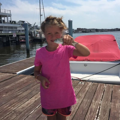 A girl angler holing a small bluefish