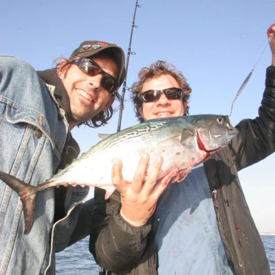 Two anglers on a boat holding a false alabacore