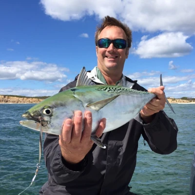 Nick Honachefsky standing in front of the water holding a false albacore