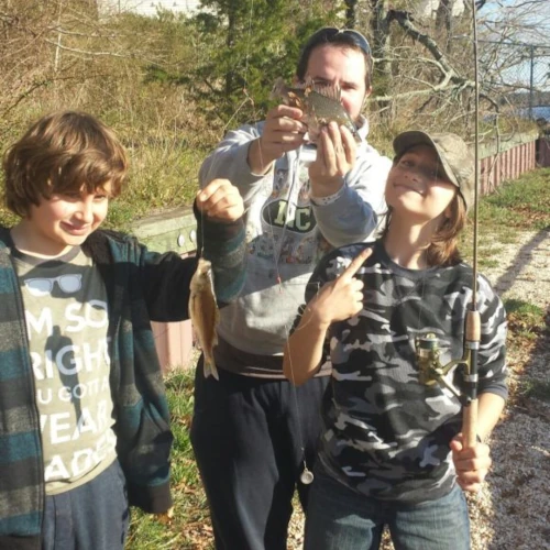 A parent and two kids with a white perch