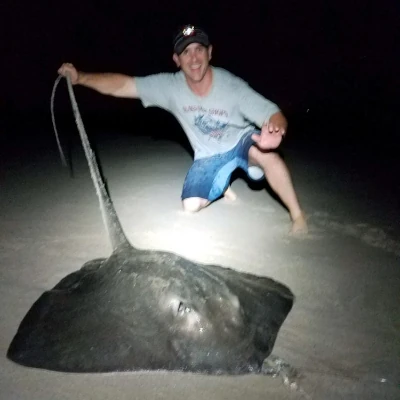 An angler the tail of a ray on the beach