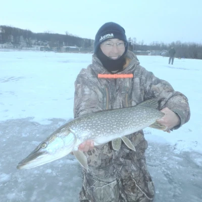 An angler holding a pike while ice fishing