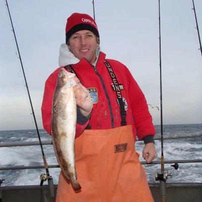 An angler holding a fishing and dressed for cold weather