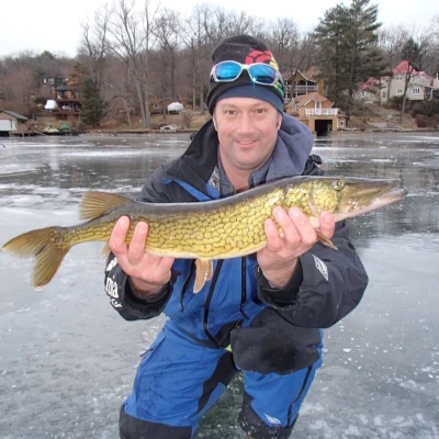 Nick Honachefsky holding a pike while out on the ice