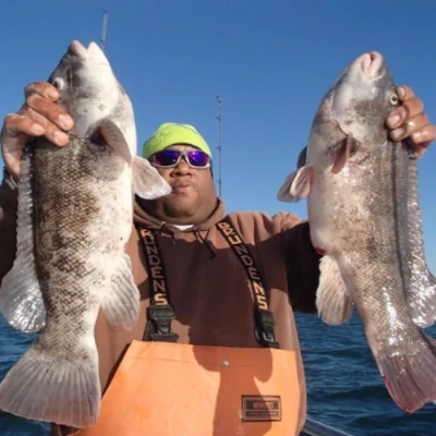 An angler holding two fish