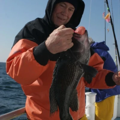 An angler dressed in warm fishing gear holding a fish