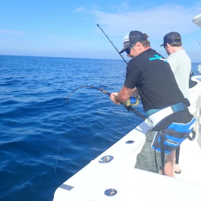 Two anglers fishing off the side of a boat