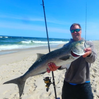Nick Honachefsky holding a bluefish while standing on the beach