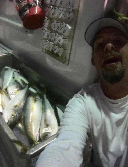 Travis Seaton in front of a bin of yellowfin