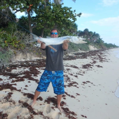 Nick Honachefsky holding a fish and a fishing rod