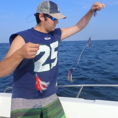 An angler on a boat holding a trolling rig