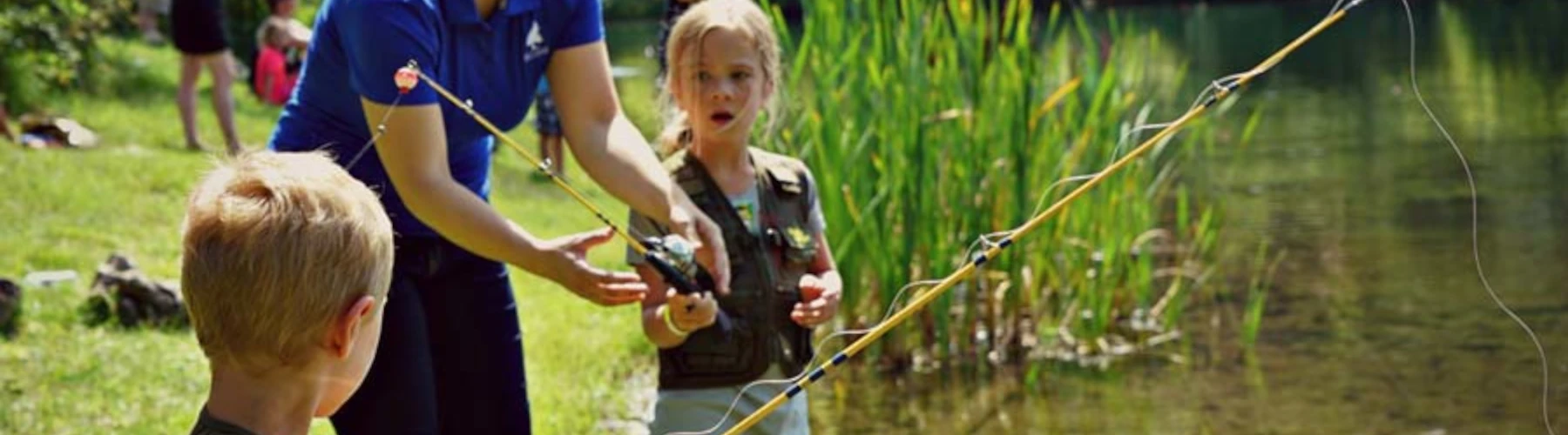 Picture of two kids learning to fish by a river