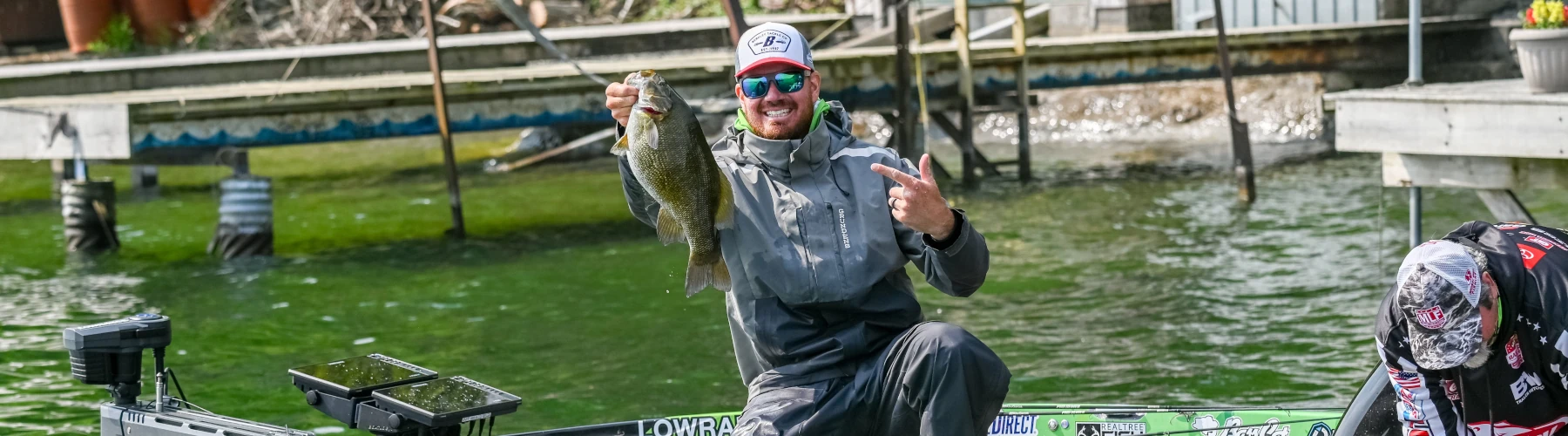 Adrian Avena holding a bass while fishing during the FLW Bass Pro Tour Tuornment on Cayuga Lake
