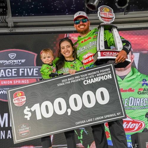 Adrian Avena standing with his family after winning and holding his trophy and $100,000 prize