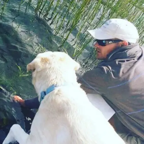 Dan Schafer and a dog on the edge of the water
