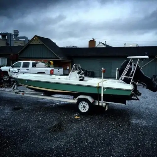 A boat on a trailer in front of a building