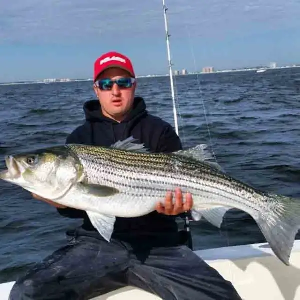 Cole Svenson holding a fish while sitting on a boat