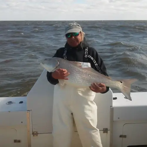 Maureen Klause on a boat holding a fish